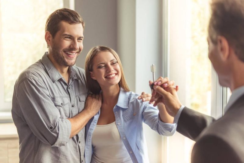 Vermieter-Downloads & Checklisten für die Immobilienvermietung 2 Ein junges Paar bekommt die Wohnungsschlüssel vom Vermieter.